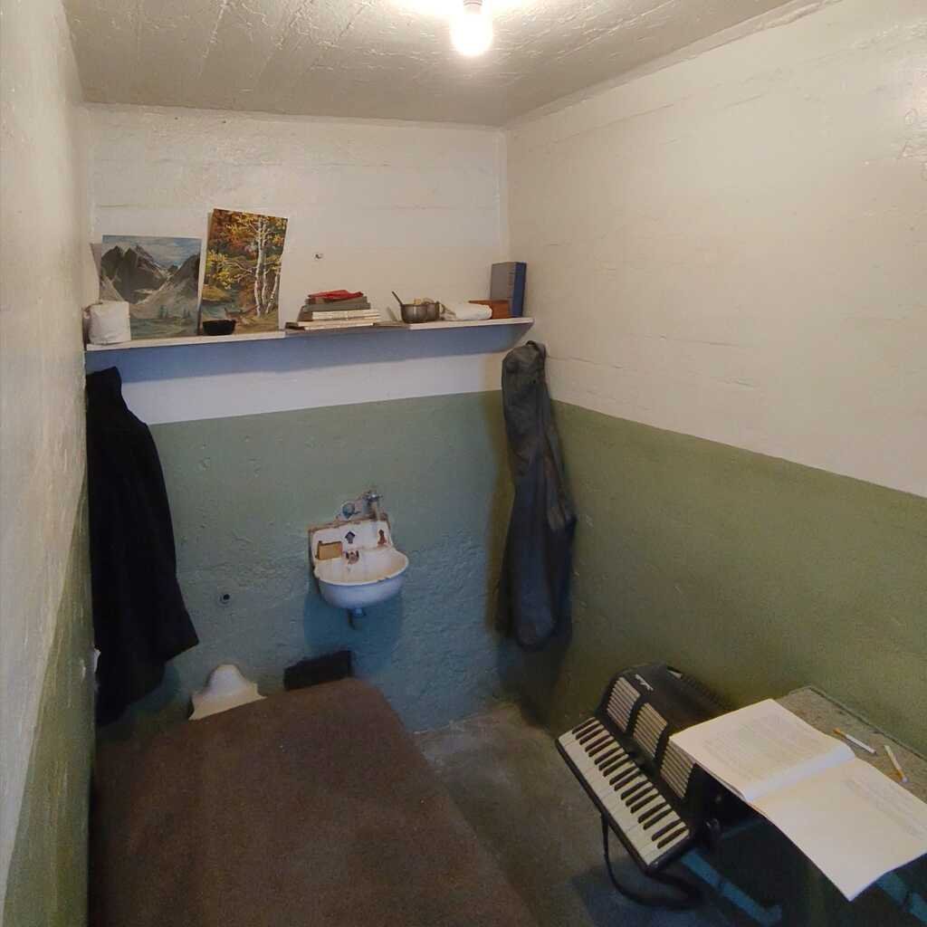 Interior de una celda en la prisión de Alcatraz con una cama y un acordeón