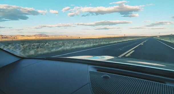 Coche de alquiler circulando por una carretera infinita durante una ruta por Estados Unidos.